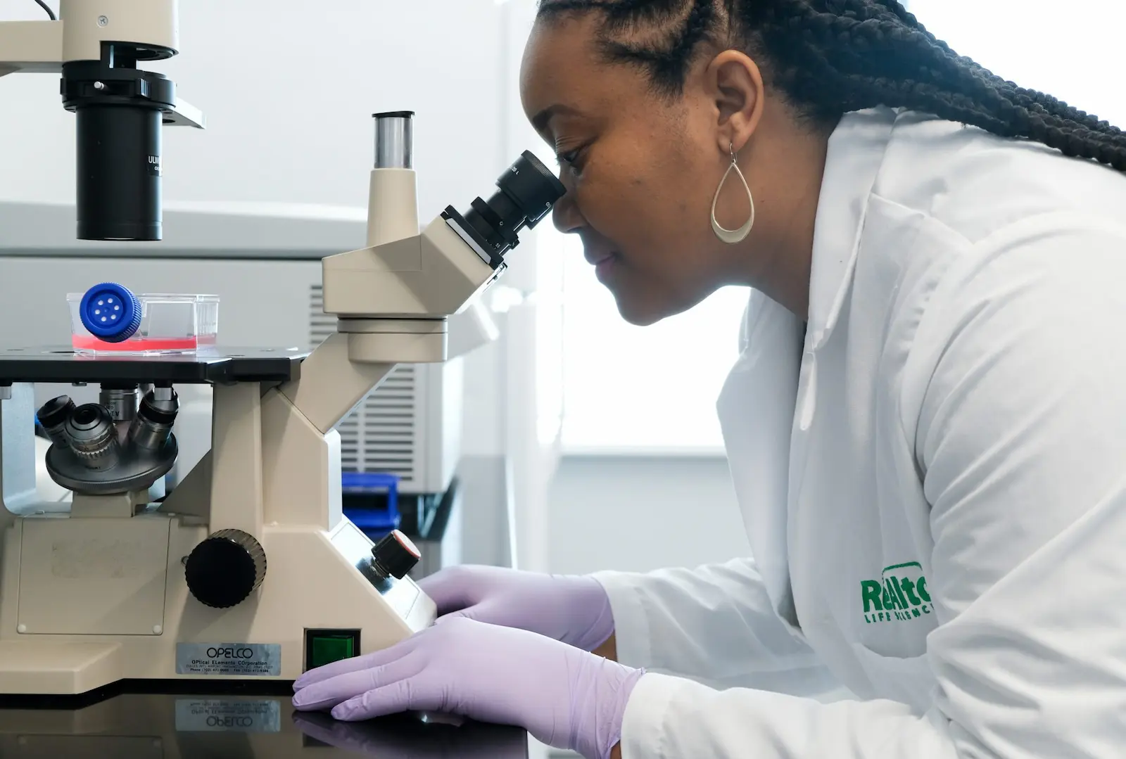 Scientist at microscope.